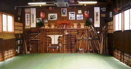 Historische Innenansicht des Bujinden Dōjō in Japan mit Tatami, Waffenregalen und Kalligraphien